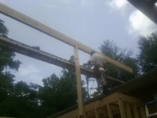 Carpenter setting a ridge beam over a new addition frame — Ice Dam Removal by Roofing Brothers in Middleton
