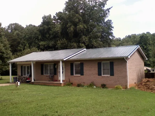 Gray metal roof on a brick ranch house with a side carport in Middleton